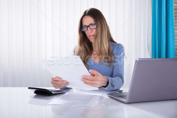 Businesswoman Reading Document In Office Stock photo © AndreyPopov