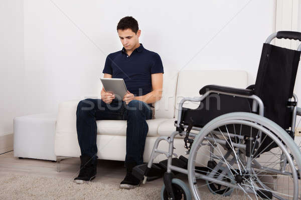 Discapacitado hombre digital tableta sofá Foto stock © AndreyPopov