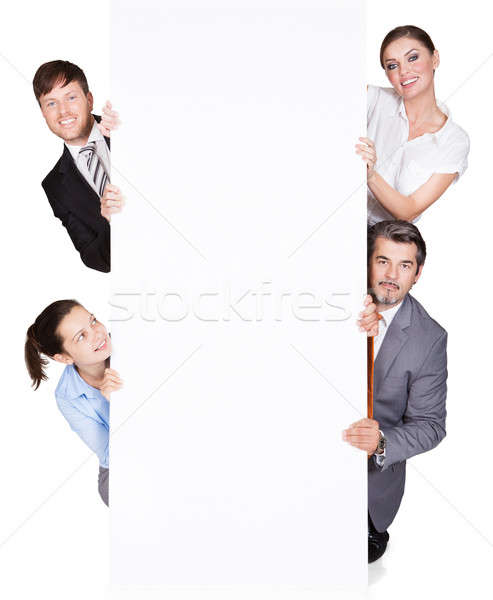 Happy Businesspeople Hiding Behind Large Billboard Stock photo © AndreyPopov