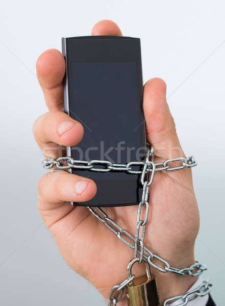 Stock photo: Businessman's Hand Chained With Mobilephone