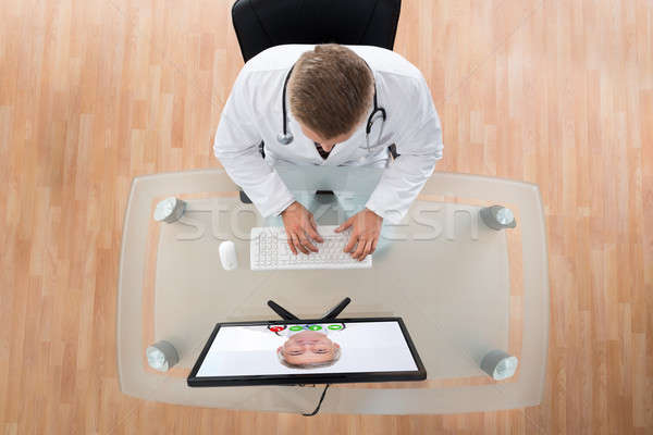 Stock photo: Doctor Videochatting With Senior Colleague On Computer