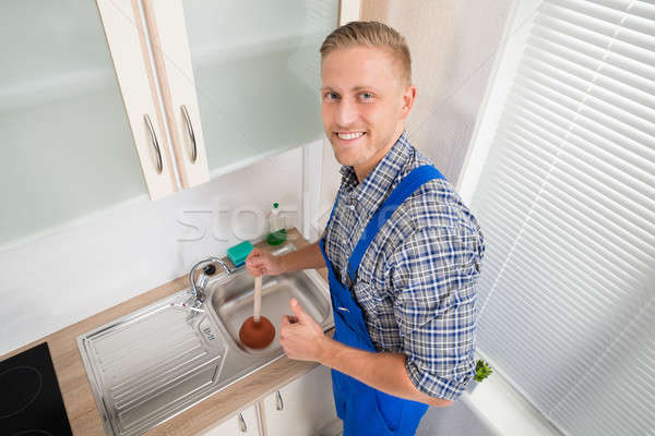 Plumber With Plunger In Kitchen Stock photo © AndreyPopov