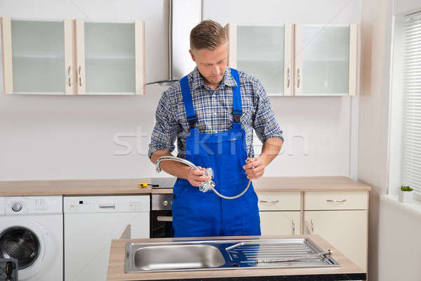 Plumber With Faucet In The Kitchen Room Stock photo © AndreyPopov