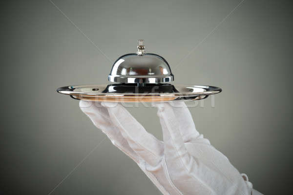 Cropped Hand Of Waiter Holding Service Bell In Tray Stock photo © AndreyPopov
