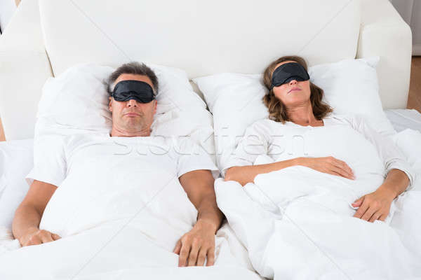 Couple Sleeping On Bed Using Eye Mask Stock photo © AndreyPopov