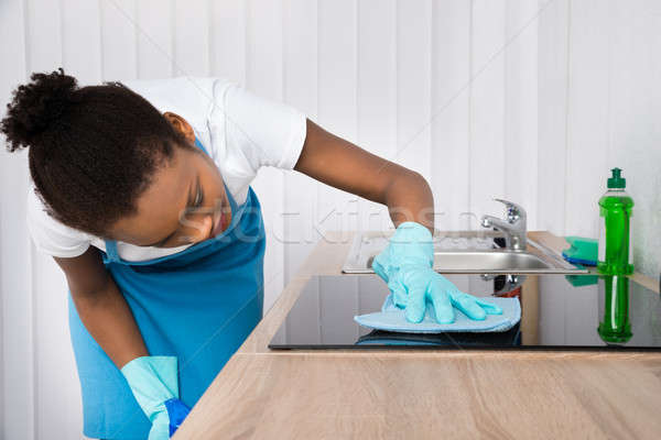 Female Janitor Cleaning Induction Stove Stock photo © AndreyPopov