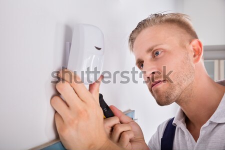 Stock photo: Man Installing Motion Detector For Security System