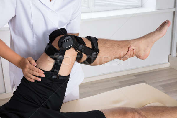 Physiotherapist Fixing Knee Braces On Man's Leg Stock photo © AndreyPopov