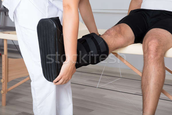 Therapist Fixing Walking Brace On Person's Leg Stock photo © AndreyPopov