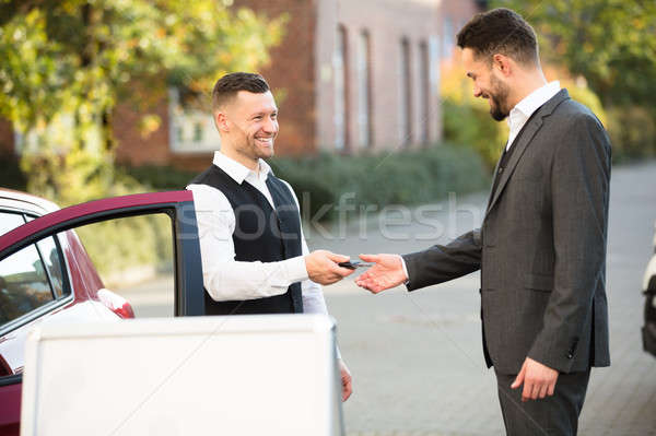Young Businessman Getting Car Key From Valet Stock photo © AndreyPopov