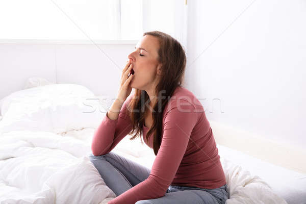 Woman Yawning On Bed Stock photo © AndreyPopov