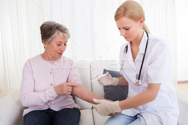 Young Doctor Injecting Vaccine To Senior Woman Stock photo © AndreyPopov