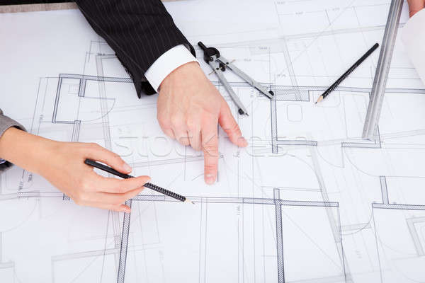 Person's Hand Pointing On Blue Print Stock photo © AndreyPopov