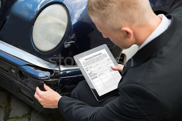 Man Holding Digital Tablet Examining Damaged Car Stock photo © AndreyPopov