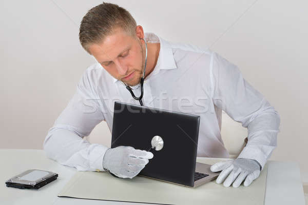 Technician Examining Laptop With Stethoscope Stock photo © AndreyPopov