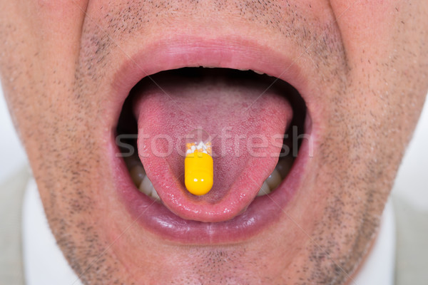Man With Medicine On Tongue Stock photo © AndreyPopov