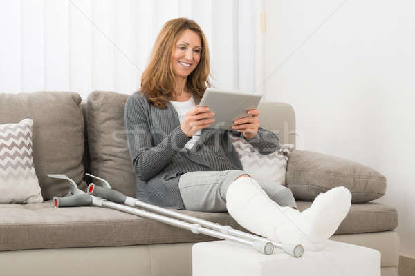 Woman With Fractured Leg Using Digital Tablet Stock photo © AndreyPopov