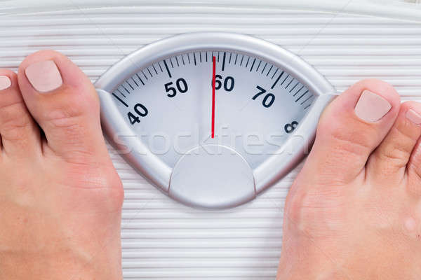 Stock photo: Person Standing On Weighing Scale