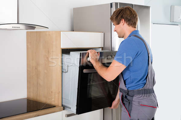 Technician In Overall Installing Oven Stock photo © AndreyPopov