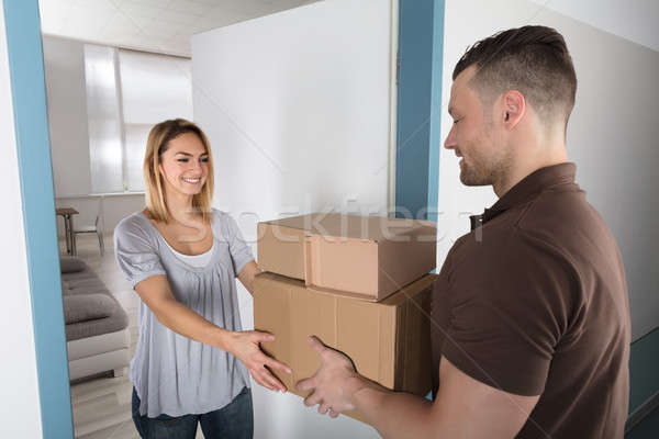 Delivery Man Giving Parcel Box To Young Woman Stock photo © AndreyPopov