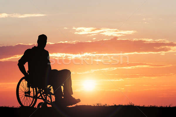 Silhouette Of A Person Sitting On Wheelchair At Sunset Stock photo © AndreyPopov