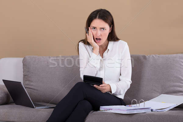 Mujer sesión sofá calculadora contabilidad Foto stock © AndreyPopov