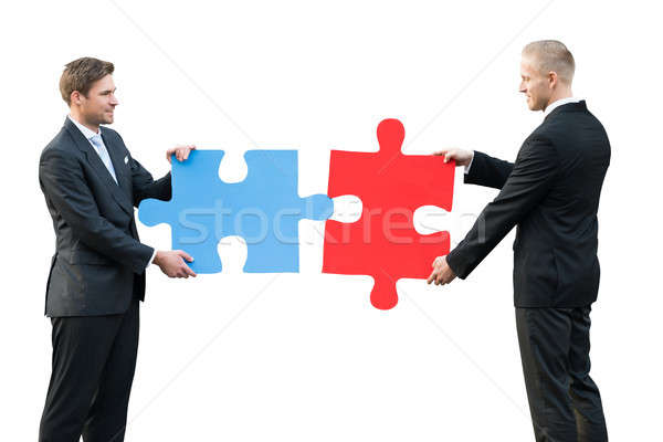 Two Businesspeople Holding Blue And Red Colored Jigsaw Puzzle Stock photo © AndreyPopov