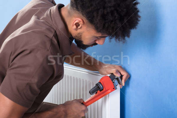 Hydraulik radiator klucz młodych mężczyzna Zdjęcia stock © AndreyPopov