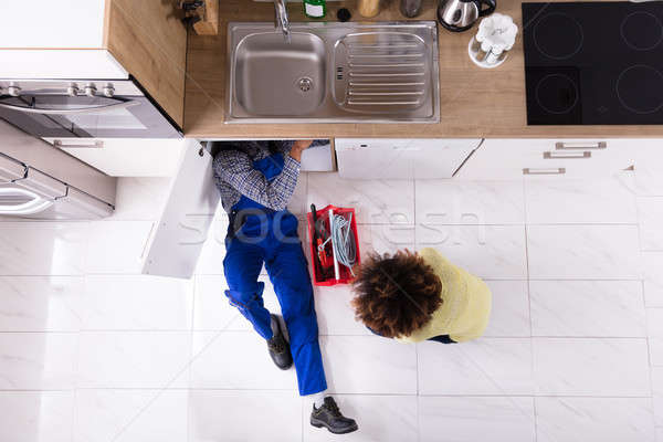 Plumber Repairing Sink In Kitchen Stock photo © AndreyPopov