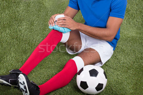 Injured Soccer Player Applying Ice Pack On Knee Stock photo © AndreyPopov