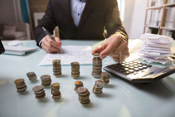 Közelkép egymásra pakolva érmék asztal üzletember dolgozik Stock fotó © AndreyPopov