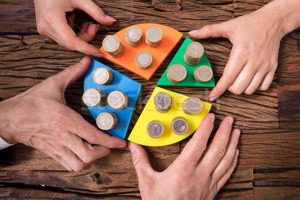 Stock photo: Businesspeople Stacking Coins On Pie Chart