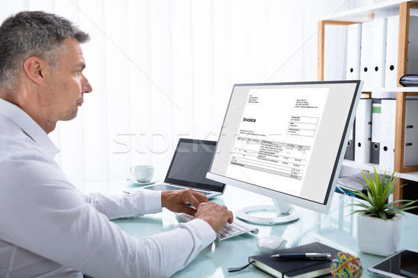 Businessman Analyzing Invoice On Computer Stock photo © AndreyPopov