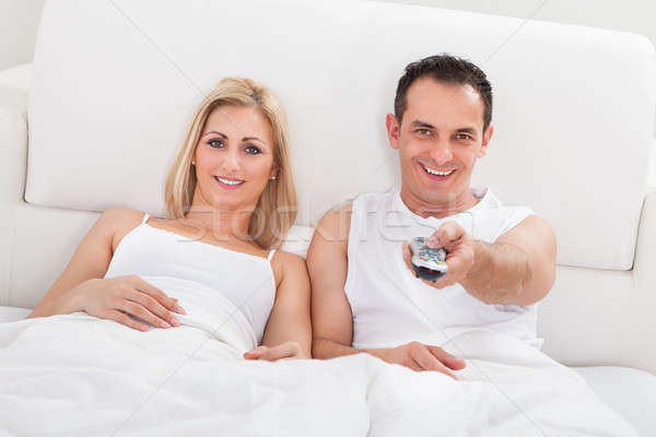 情侶 放寬 床 看電視 遙控 手 商業照片 © AndreyPopov
