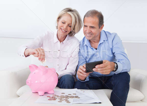 Stock photo: Mature Couple Calculating Coin In The Piggybank