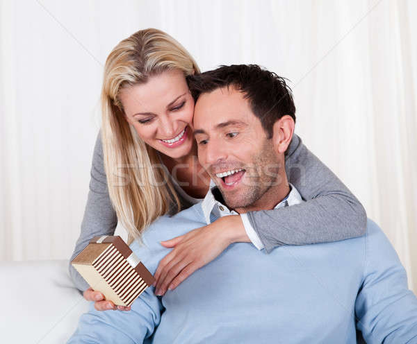 Woman giving her husband a surprise gift Stock photo © AndreyPopov