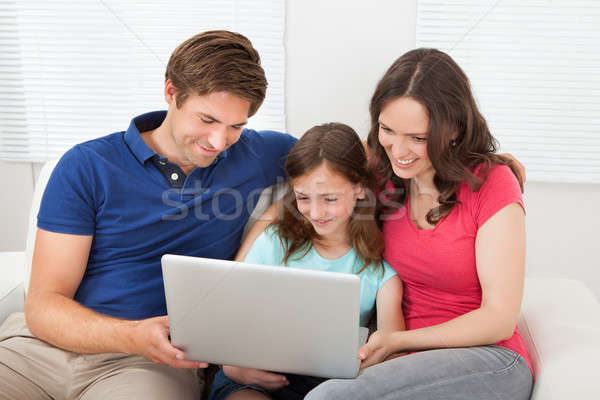 Rodziny za pomocą laptopa sofa szczęśliwą rodzinę trzy wraz Zdjęcia stock © AndreyPopov