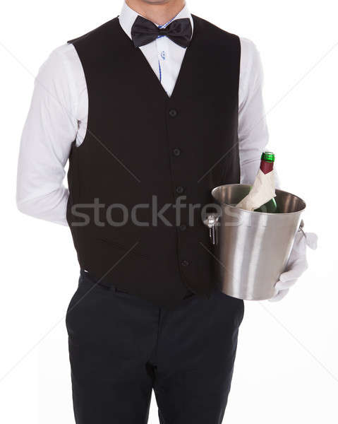 Waiter Holding Champagne Bottle In Cooler Stock photo © AndreyPopov