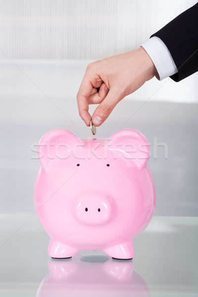 Businessman Inserting Coin In Piggybank In Office Stock photo © AndreyPopov