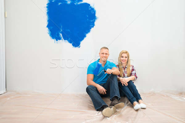Happy Couple In Front Of Partially Painted Wall Stock photo © AndreyPopov