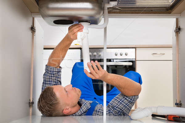 Plumber Fixing Pipe Into The Sink Stock photo © AndreyPopov