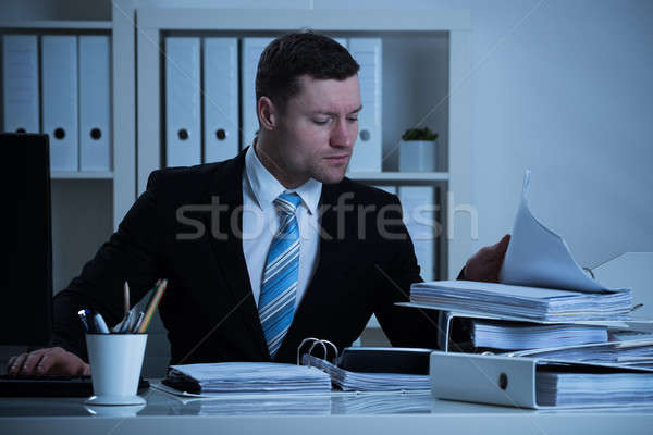 Businessman Working Late In Office Stock photo © AndreyPopov