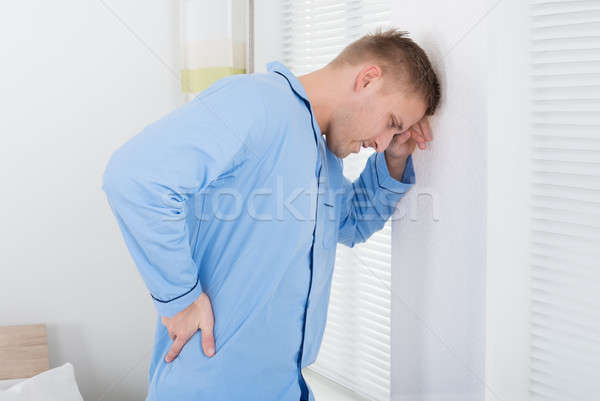 Young Man Suffering From Back Ache Stock photo © AndreyPopov