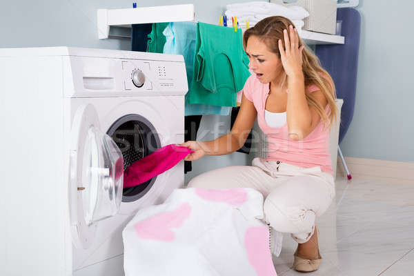 Mulher olhando manchado pano máquina de lavar roupa Foto stock © AndreyPopov