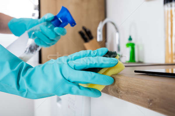 Stock photo: Janitor Cleaning Kitchen Worktop