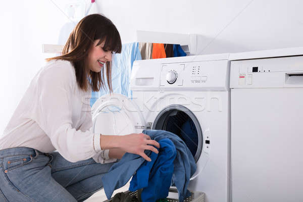 Stock photo: Woman Putting Dirty Cloth Into Washing Machine