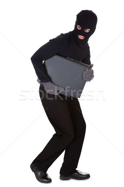 Stock photo: Thief stealing a laptop computer