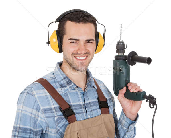 Worker holding drill and wearing hard hat Stock photo © AndreyPopov