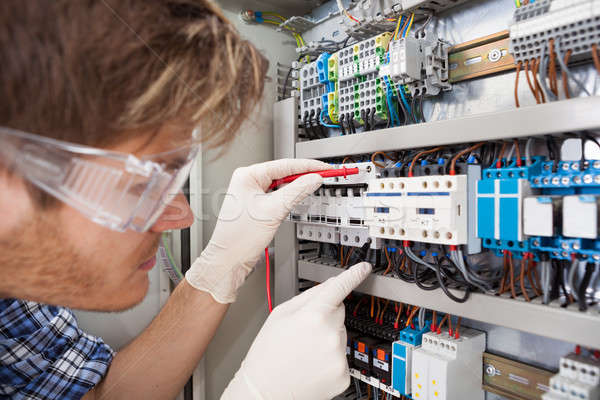Electrical Engineer Examining Fusebox With Multimeter Probe Stock photo © AndreyPopov