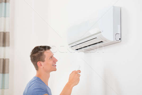 Man With Remote Control To Operate Air Conditioner Stock photo © AndreyPopov